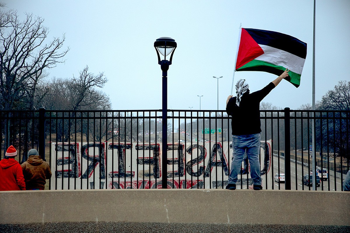 Mohammed Ghannam, right, waves a Palestinian flag to drivers on I-44 from Tamm Avenue during a protest for Palestinian liberation on Friday, Feb. 2, 2024.
