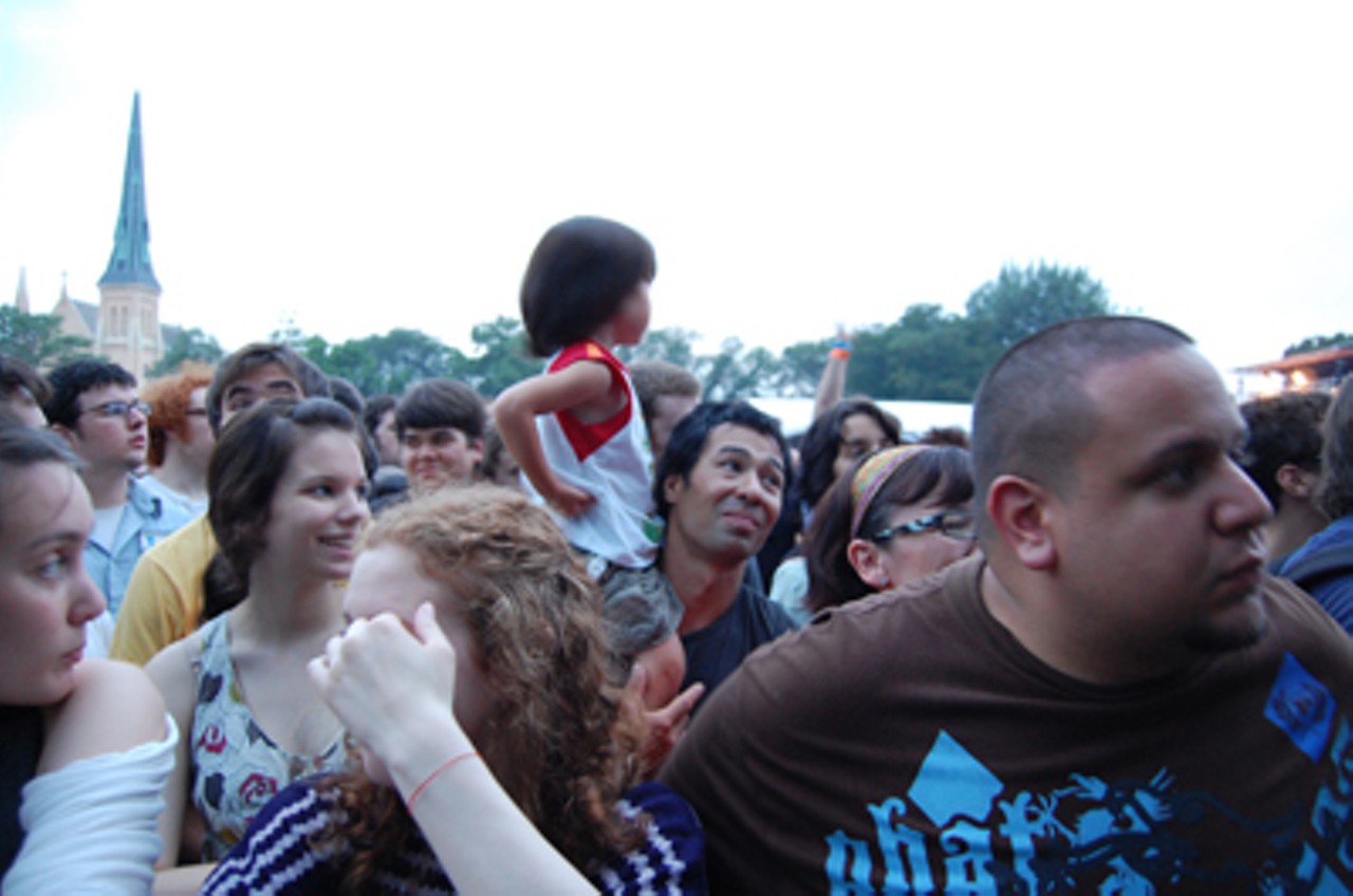 A man hoists a little girl onto his shoulders during a performance by the Bomb Squad, a duo who are the producers for Public Enemy. The bass was deafening.