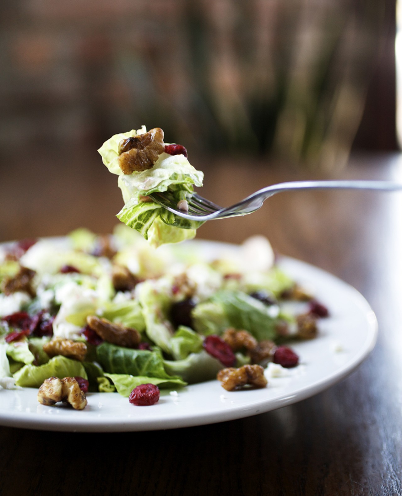The Bistro Salad is Romaine lettuce, red grapes, dried cranberries, candied walnuts and feta cheese. It is served with fat free raspberry vinaigrette.