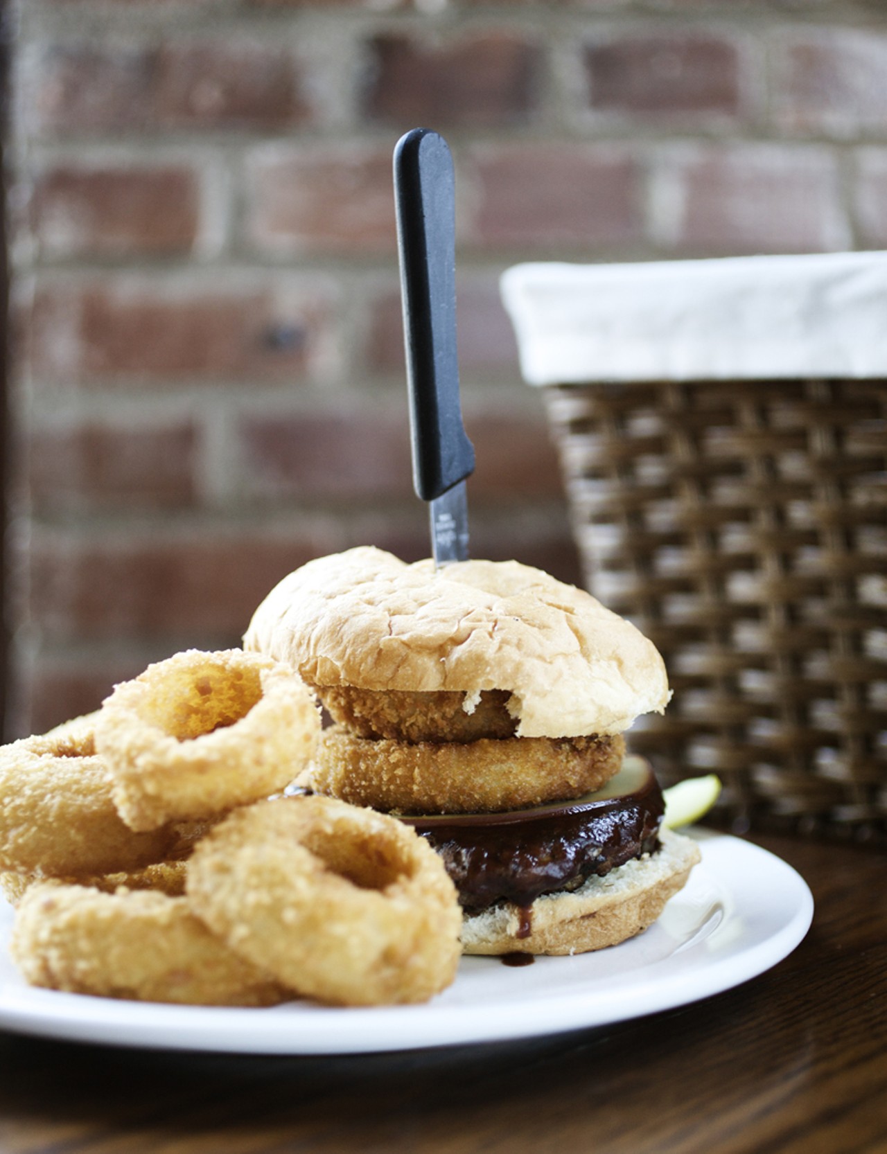 The One Eyed Jack Burger is stacked with onion rings, smoked Gouda, and their own Bourbon BBQ sauce.