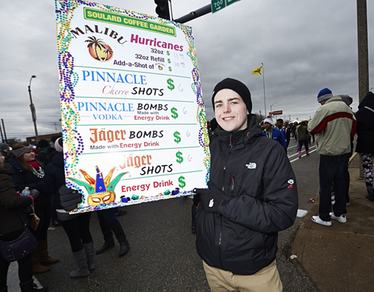 John Nettles holds a sign advertising Soulard Coffee Garden's Mardi Gras drink specials.