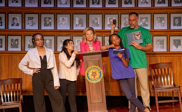 The characters of What the Constitution Means to Me stand on a titled stage.