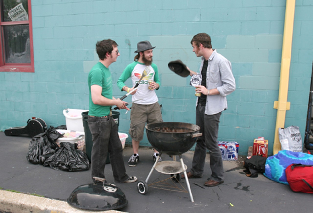 Jason Matthews and Tim Andrew, of The Monads, and Chris Baricevic, of Big Muddy Records, prepare to grill burgers and hot dogs.