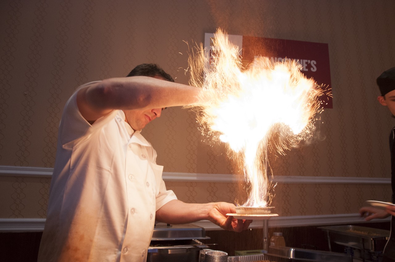 The chef from Evangelines sprinkling their bananas foster and rum with spice that makes it explode with flavor.