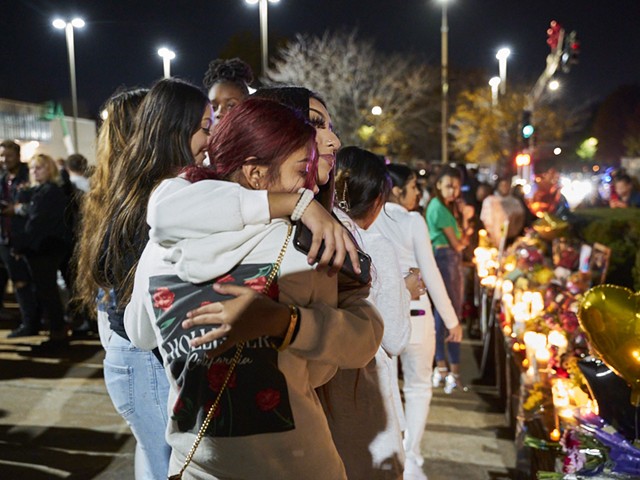 Students hug at a vigil after the shooting at Central Visual and Performing Arts High School. Politicians argue that teachers could protect students by carrying guns in the classroom.
