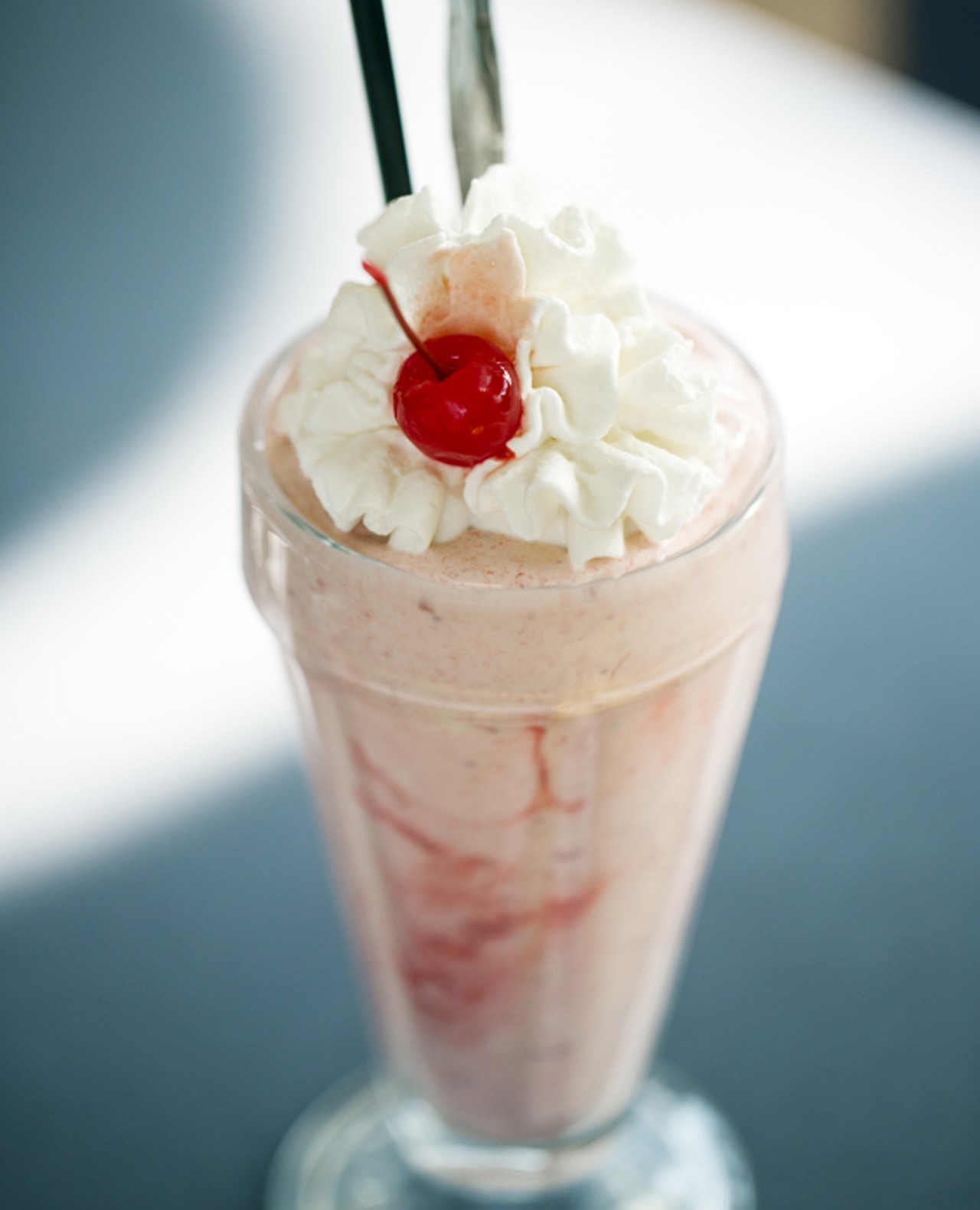Strawberry milkshake with a cherry on top.