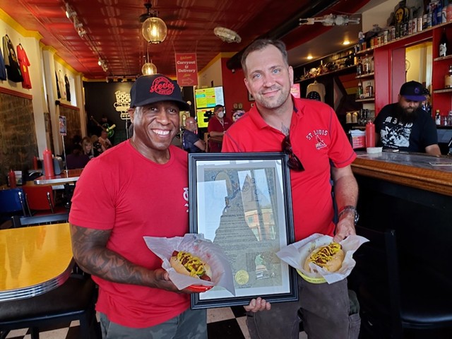 Founder and co-owner of Steve's Hot Dogs and Burgers, Steve Ewing, and Chef Joseph Zeable with the St. Louis-Style dog and the resolution from the City of St. Louis, making it the city's official hot dog.