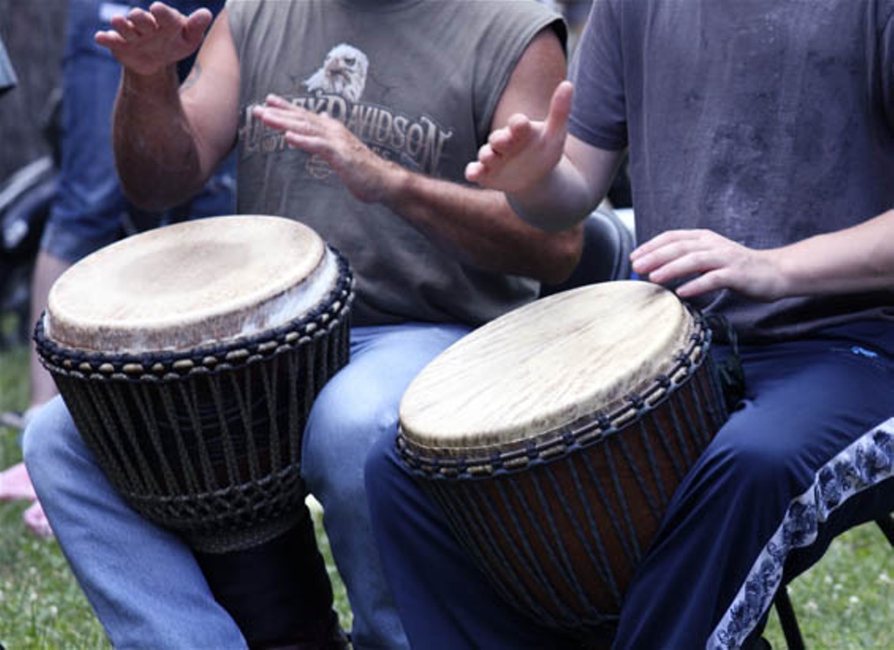 Attendees of the picnic form a drum circle.