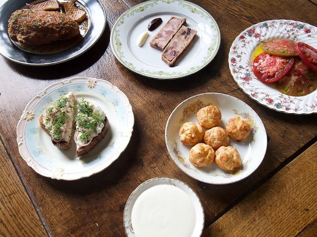 A selection of dishes from Bistro La Floraison including (clockwise from top left) fried chicken cordon bleu, duck pate en croute, heirloom tomato salad, gougeres and smoked trout rilette.