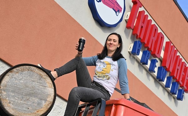 Abbey Spencer, head brewer, poses in front of Third Wheel Brewing.