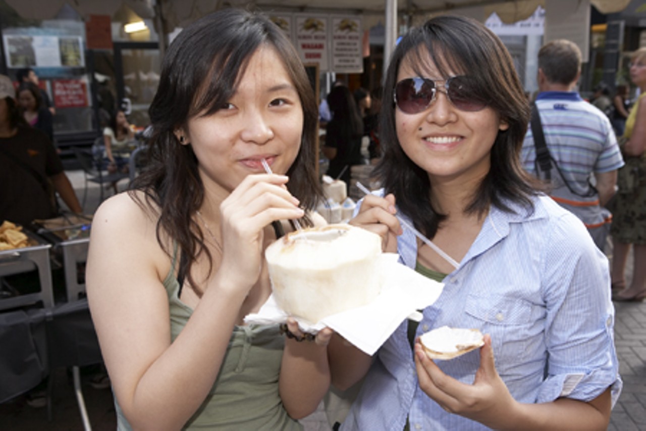 Two ladies enjoying some coconuts at the Wasabi Festival.