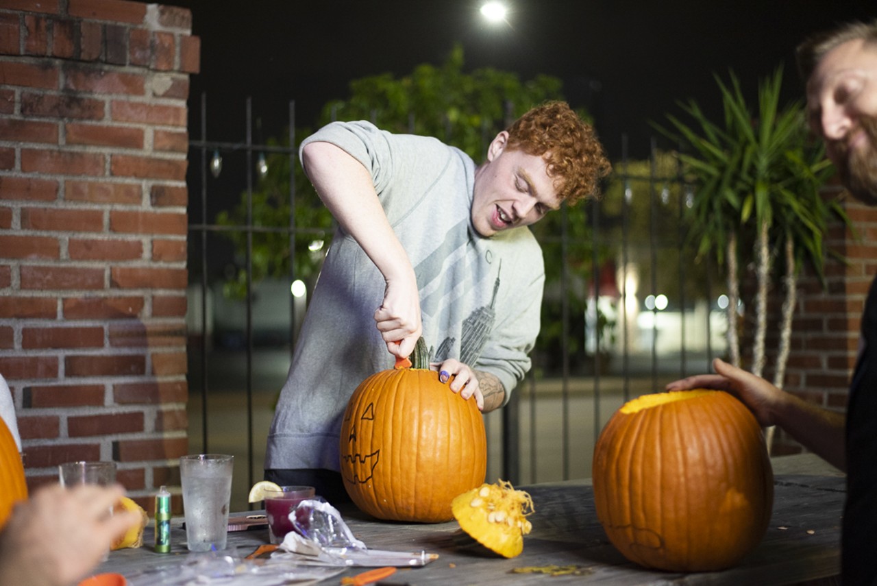 An attendee carves a pumpkin.
