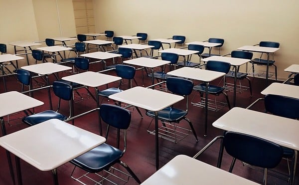 Empty school desks in a classroom.