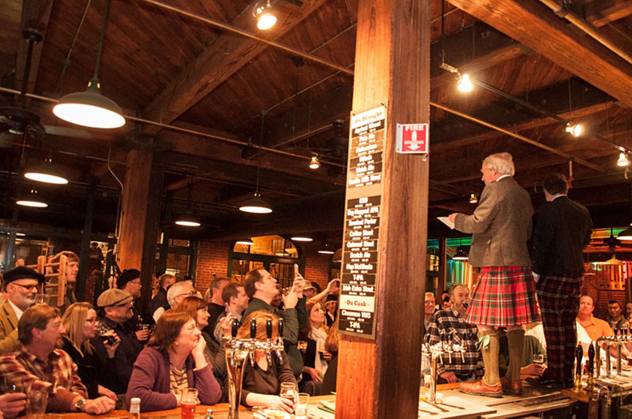 Tom Schlafly and Dan Kopman stand on the bar telling the legendary story of Robert Burns.
