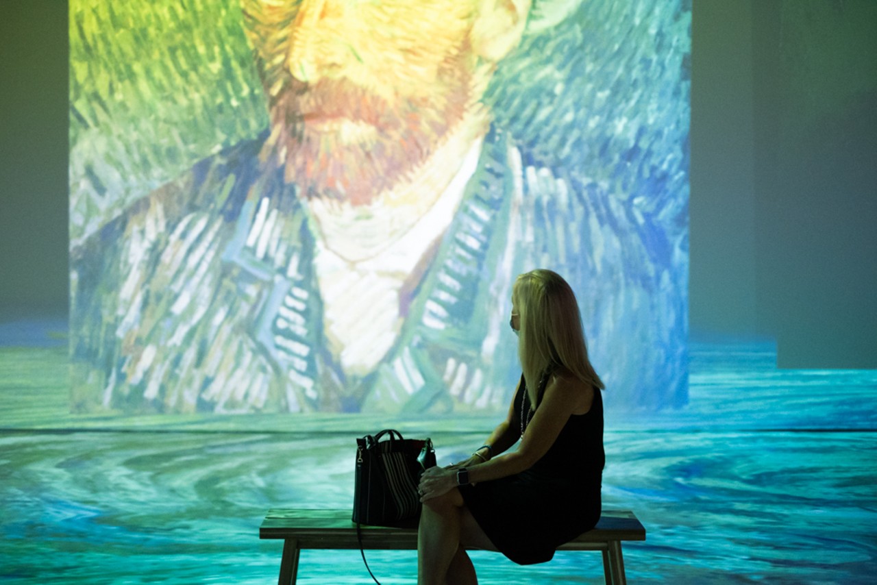 A woman observing one of van Gogh's self-portraits.
