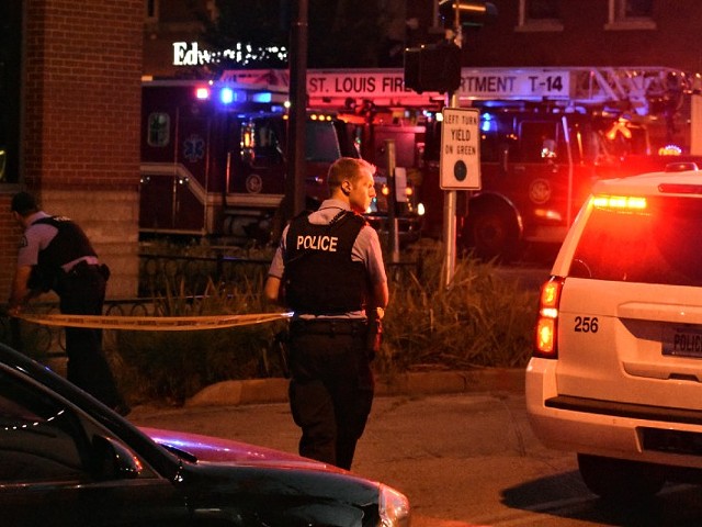 St. Louis police officers stretch crime scene tape across the street after an two officers were shot on Hartford Street.