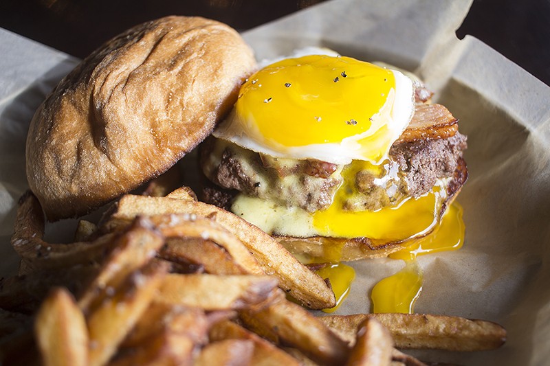 The "Wake and Bake" burger tops an eight-ounce patty with pork belly confit, hollandaise aioli and a sunny-side up egg. - PHOTO BY MABEL SUEN