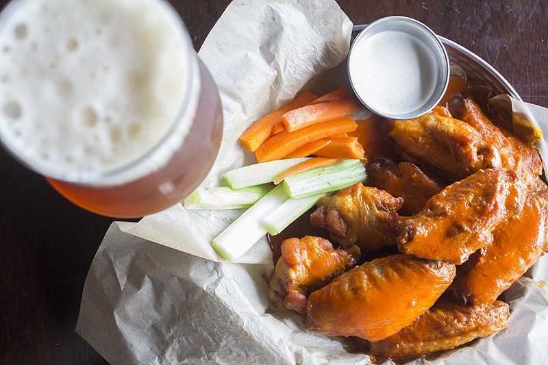 Beer-brined wings are fried, then topped with classic buffalo sauce. - PHOTO BY MABEL SUEN