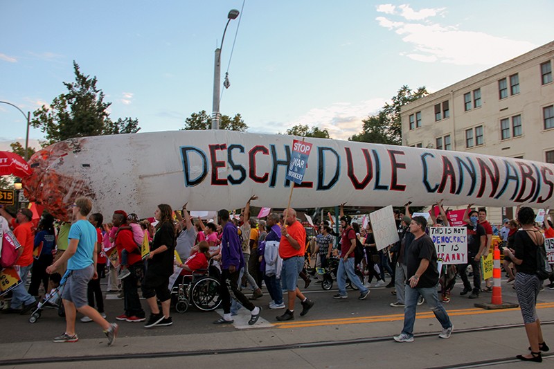 Legalization supporters carry a giant inflatable joint near the site of the 2016 presidential debate in St. Louis. - PHOTO BY DANNY WICENTOWSKI