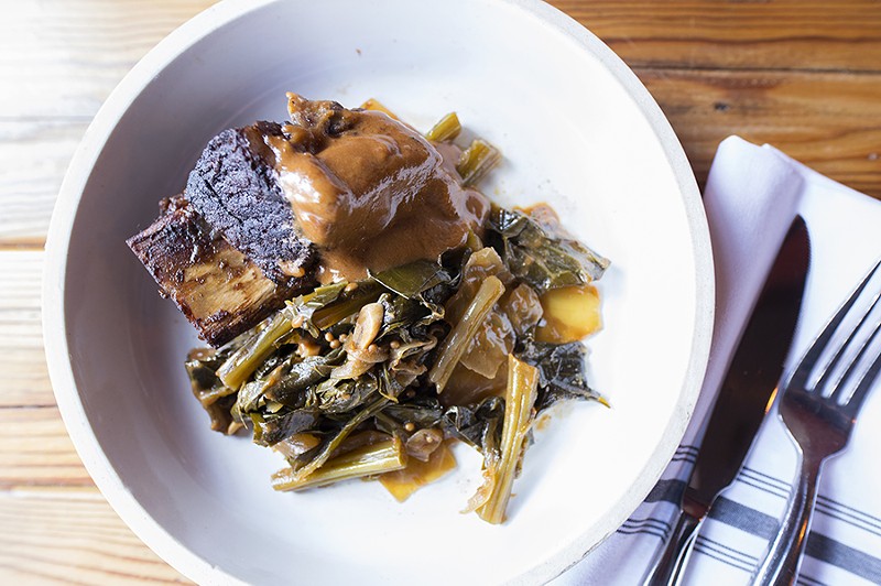 The short rib comes with house steak sauce, braised greens and black-eye peas. - MABEL SUEN