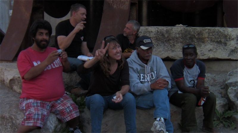 Stephanie, a volunteer, sits with residents of Tent City. In the film, Stephanie ponders at what point is being too involved no longer healthy. - SCREEN SHOT FROM LIVING IN TENTS