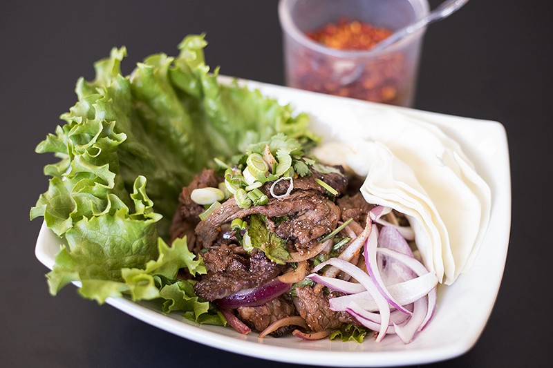 Nam tok beef offers grilled slices of steak, cilantro, red and green onion, in chile lime sauce. - MABEL SUEN