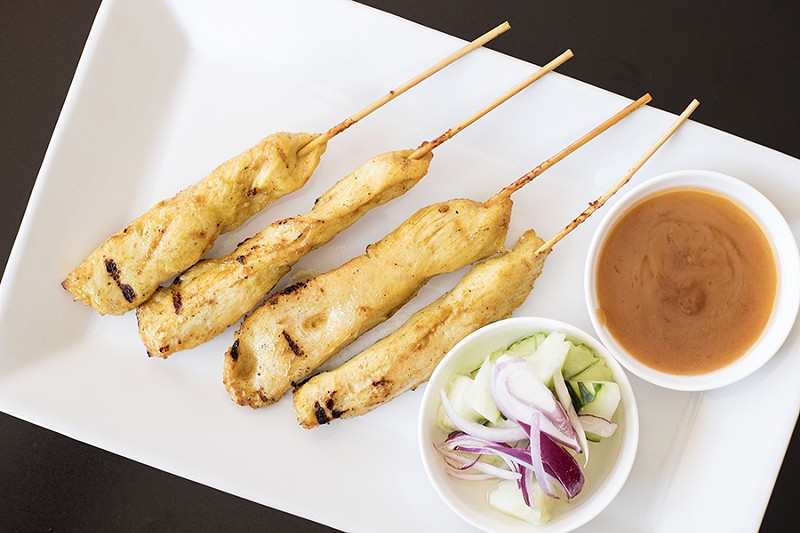 Chicken satay is served with peanut sauce and cucumber salad. - MABEL SUEN