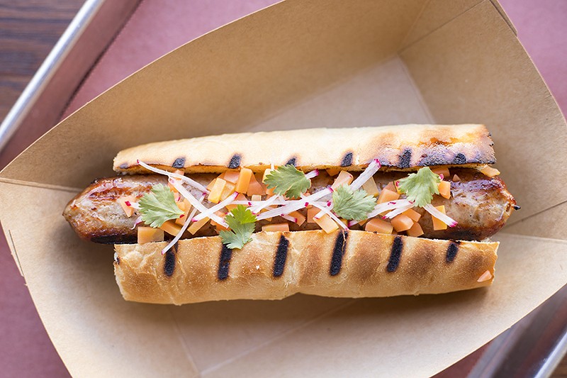 Rabbit sausage is topped with pickled carrot, local radish and cilantro. - MABEL SUEN