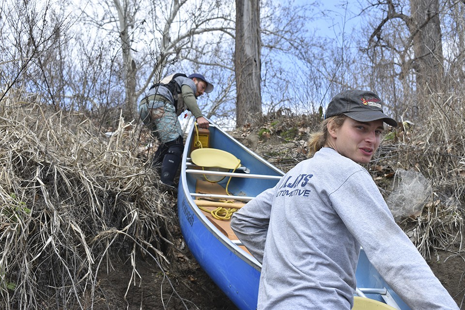 Paul Gruber, left, and Tanner Aljets of Big Muddy Adventures haul a canoe up a ten-foot embankment. - DOYLE MURPHY