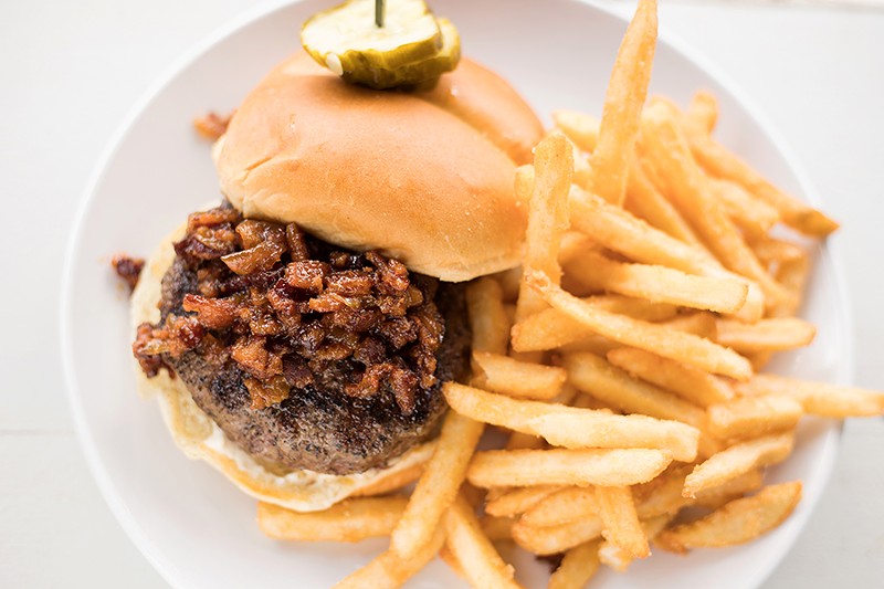 The house burger is topped with beer cheese and bacon onion jam and served with fries. - MABEL SUEN