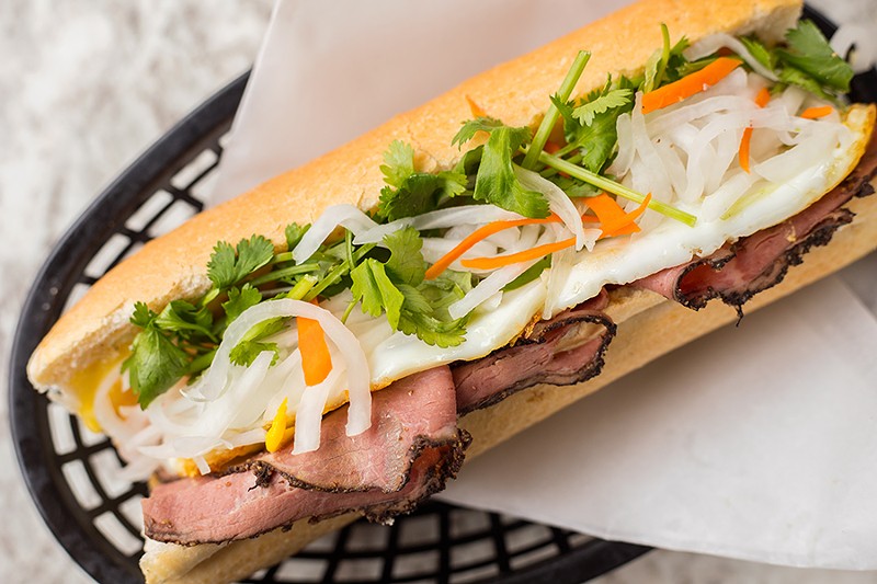 The beef pastrami bánh mì is topped with a sunny-side-up egg, pork pâté, pickled radish and carrots, jalapeño, cucumber and cilantro. - MABEL SUEN
