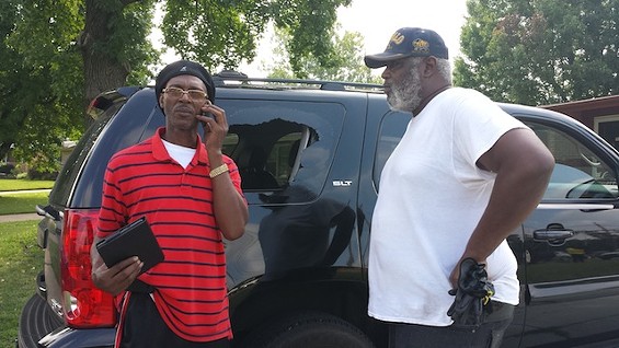 Donald Harry (right) inspects his truck window that was shot out Monday night in Ferguson. - Photo by Jessica Lussenhop