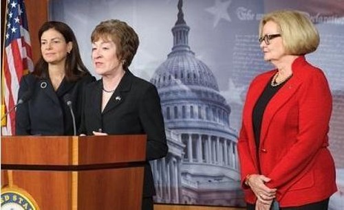 Senator Susan Collins, at the podium, stands with Senator Claire McCaskill, on the right.