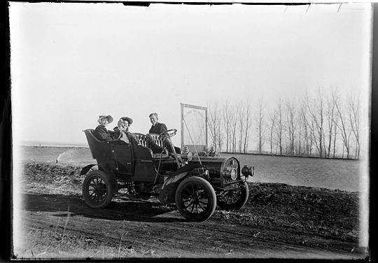 A young man and his two lady friends take a spin in the new-fangled invention of the day, the gas-powered automobile. - Courtesy of John Foster