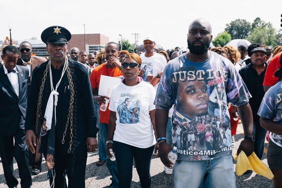 Michael Brown's parents, Lesley McSpadden and Michael Brown Sr., march wearing images of their dead son. - Bryan Sutter