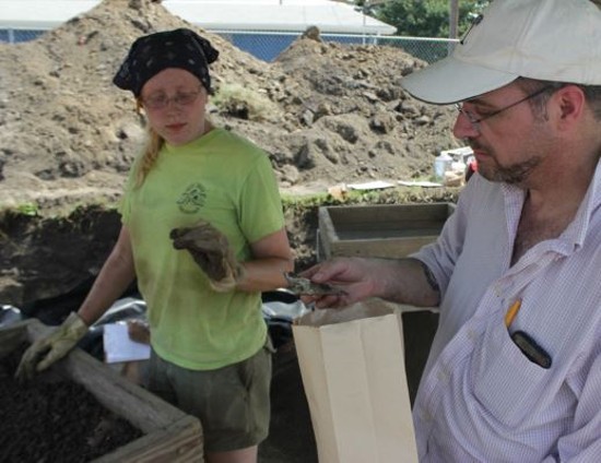 Joseph Galloy examines a 19th-century piece of glass uncovered at the dig site. - Danny Wicentowski