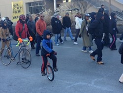 Finn McNamee, eight, rides his unicycle in the MLK parade yesterday. Big photos below.
