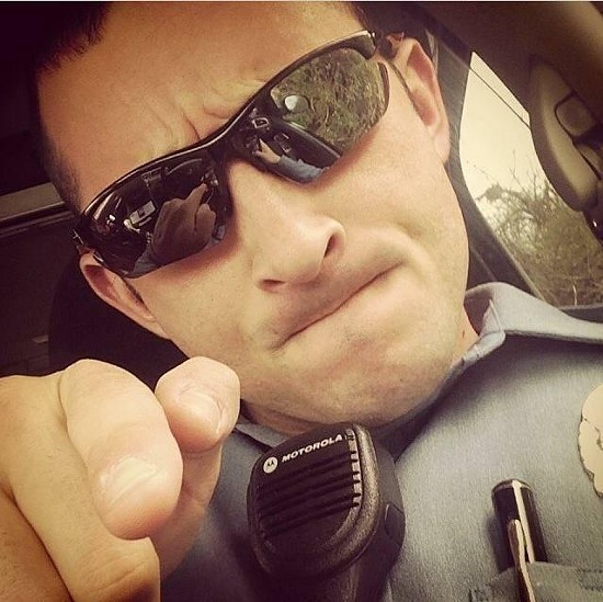 Ferguson police officer Justin Cosma arrested two journalists on August 13. - Twitter/RyanReilly