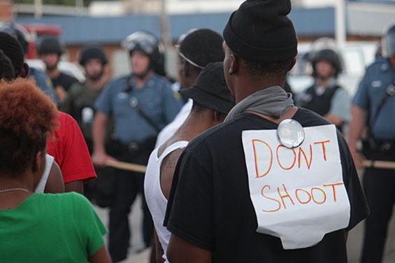 Protesters face police in riot gear in the days after Michael Brown's death. - Danny Wicentowski
