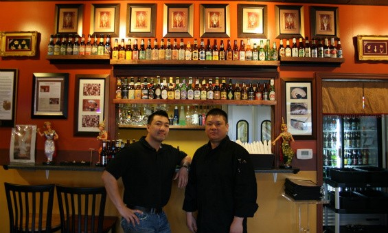 Brothers Tommy (left) and Scott (right) Truong in front of Pearl Cafe's beer selection - Chrissy Wilmes