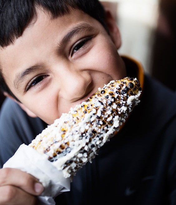 Owner and chef Jason Tilford's ten-year-old son, Julian, eating some roasted street corn. - Jennifer Silverberg