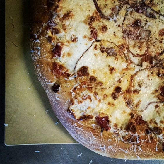 Sicilian flat bread with mozzarella, onions and oregano blossoms at Salume Beddu. | Instagram/@salumebeddu