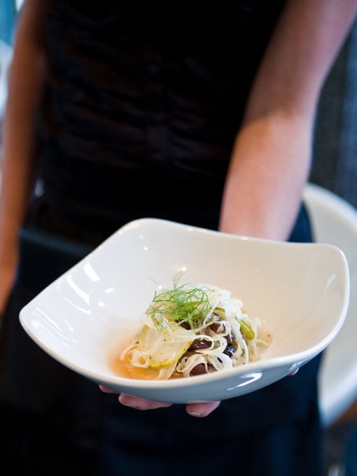 An Eclipse server holds a shaved fennel and pear with olives salad. - Photo: Stew Smith