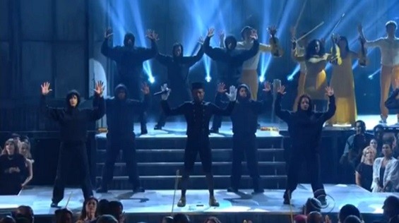 Pharrell's backup dancers wore black hooded sweatshirts to honor Trayvon Martin, and also raised their hands in a familiar pose. - Screenshot via CBS