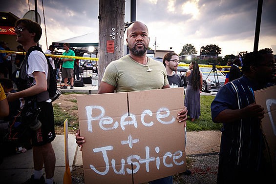 A protester in Ferguson calls for justice and peace. - STEVE TRUESDELL