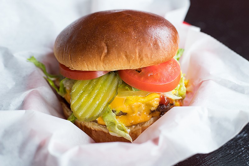 The triple Angus burger comes with caramelized onions, pickles and cheese. - MABEL SUEN