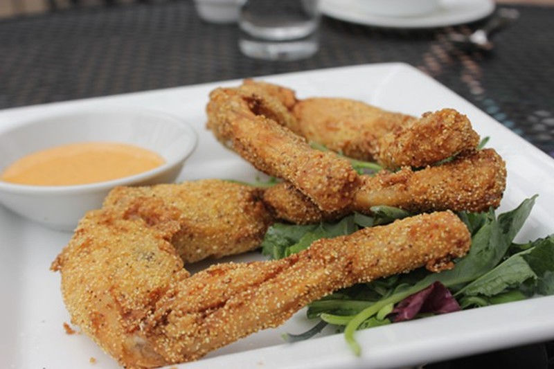 Frog legs, served on a bed of peppery arugula. - Photo by Sarah Fenske