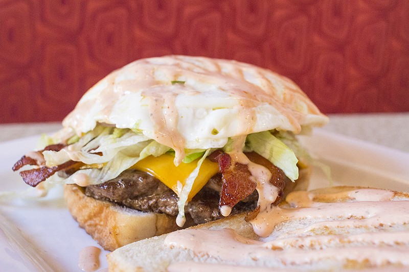 The "SLD Burger" comes with two quarter-pound patties, cheddar, bacon, an over-easy egg, shredded lettuce, red onion and Sriracha ranch on Texas toast. - PHOTO BY MABEL SUEN