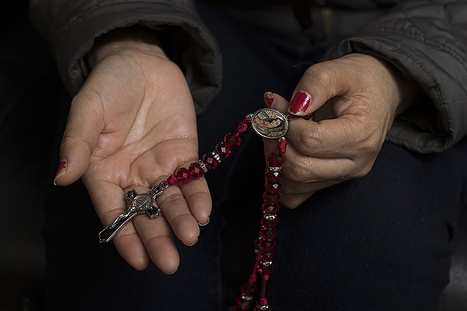 Areli Reyes' mother, Maria, grasps her rosary. - ZIA NIZAMI
