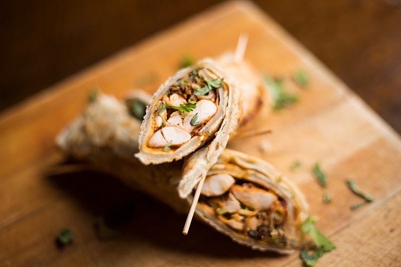 The Chicken wrap stuffs garlic naan with smoked chicken, barbecue sauce, cheese, pickles and sautéed Brussels sprouts. - MABEL SUEN